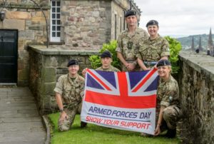 Armed Forces personnel with Armed Forces Day flag