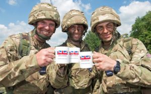 Army Reservists holding Armed Forces Day mugs.