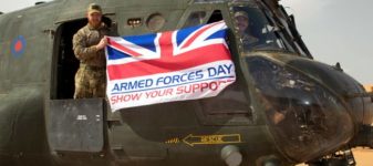 Armed Forces personnel holding the Armed Forces day flag