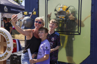 A family pose with a Royal Navy Diver at Armed Forces Day in Falmouth.
